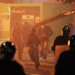 A rioter throws a burning wooden plank at police in Tottenham Aug. 7, 2011. (Lewis Whyld/PA/AP)