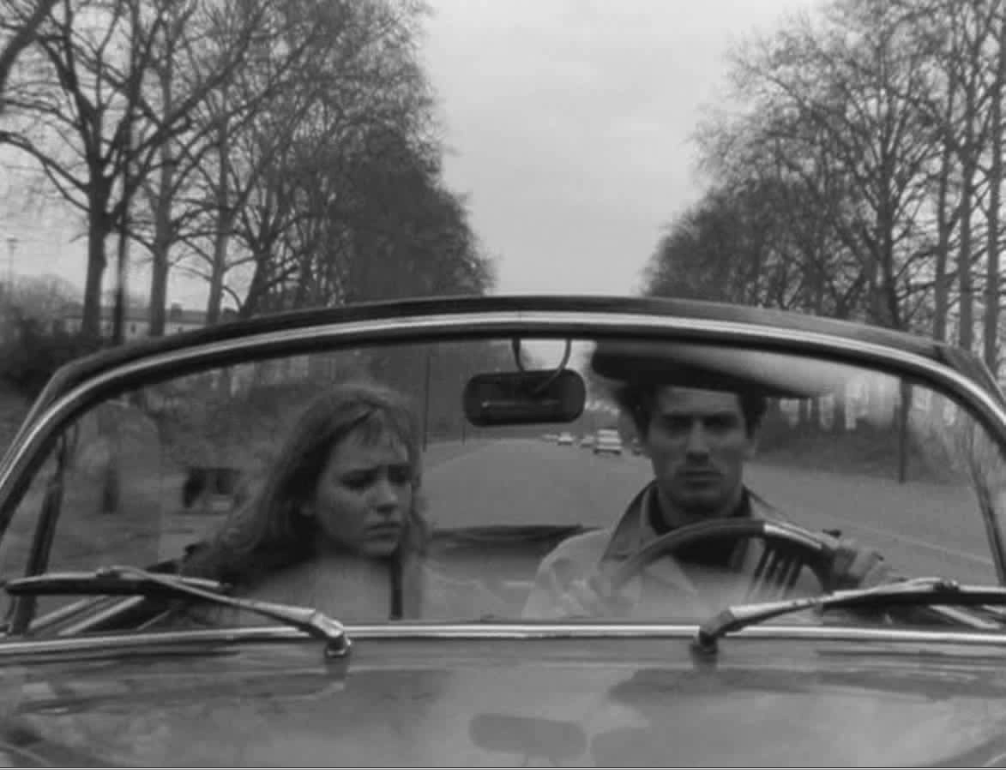 Still from the movie 'Band of Outsiders' by Jean-Luc Godard showing Anna Karina and Samy Frey in a car having a conversation