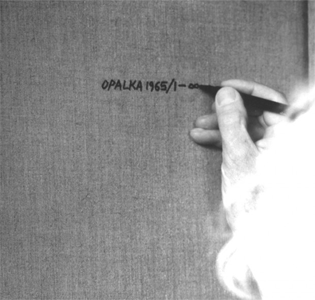 Roman Opałka signing the back of one of his "Detail" paintings