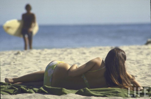 Woman lying on the beach by Co Rentmeester, California, April 1970